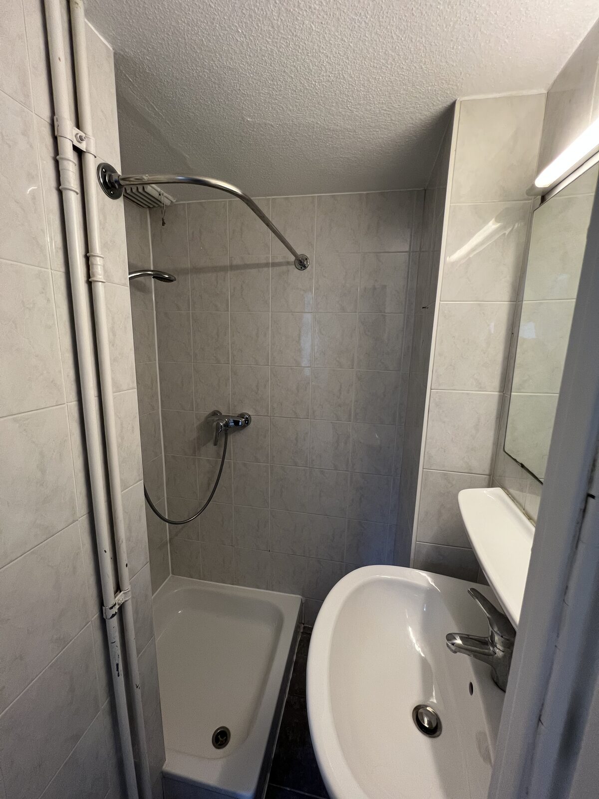 Badkamer met lavabo en spiegel van het appartement met 1 slaapkamer in Antwerpen