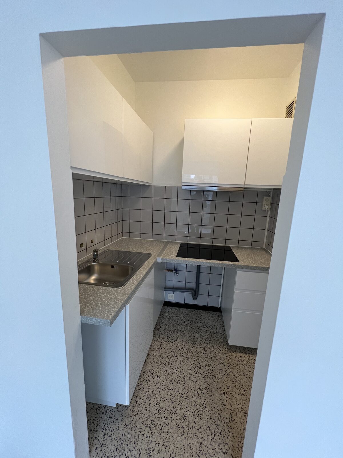 Keramische kookplaat met vier zones en spoelbak in de keuken van het appartement