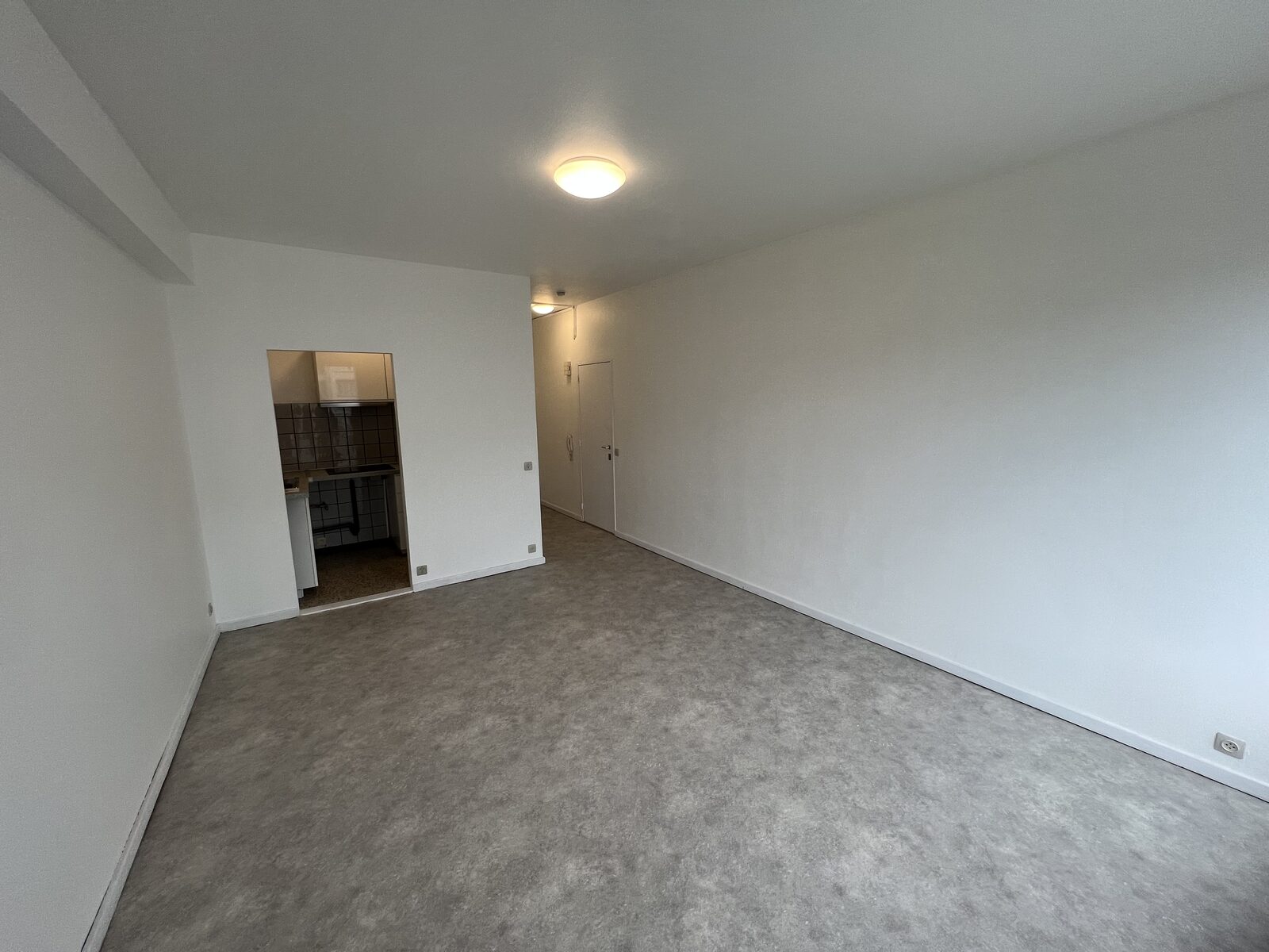 Leefruimte met zicht op de halfopen keuken van het appartement aan de Belgiëlei