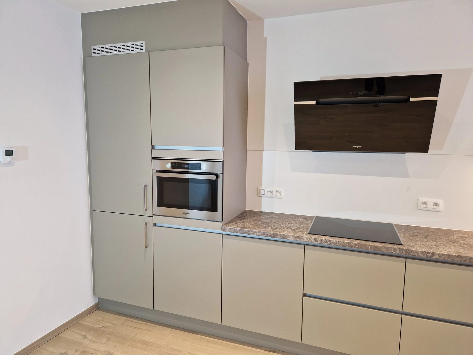 Inbouwtoestellen in de keuken: inductiekookplaat met geïntegreerde afzuiging, koelkast met diepvriezer en vaatwasser
