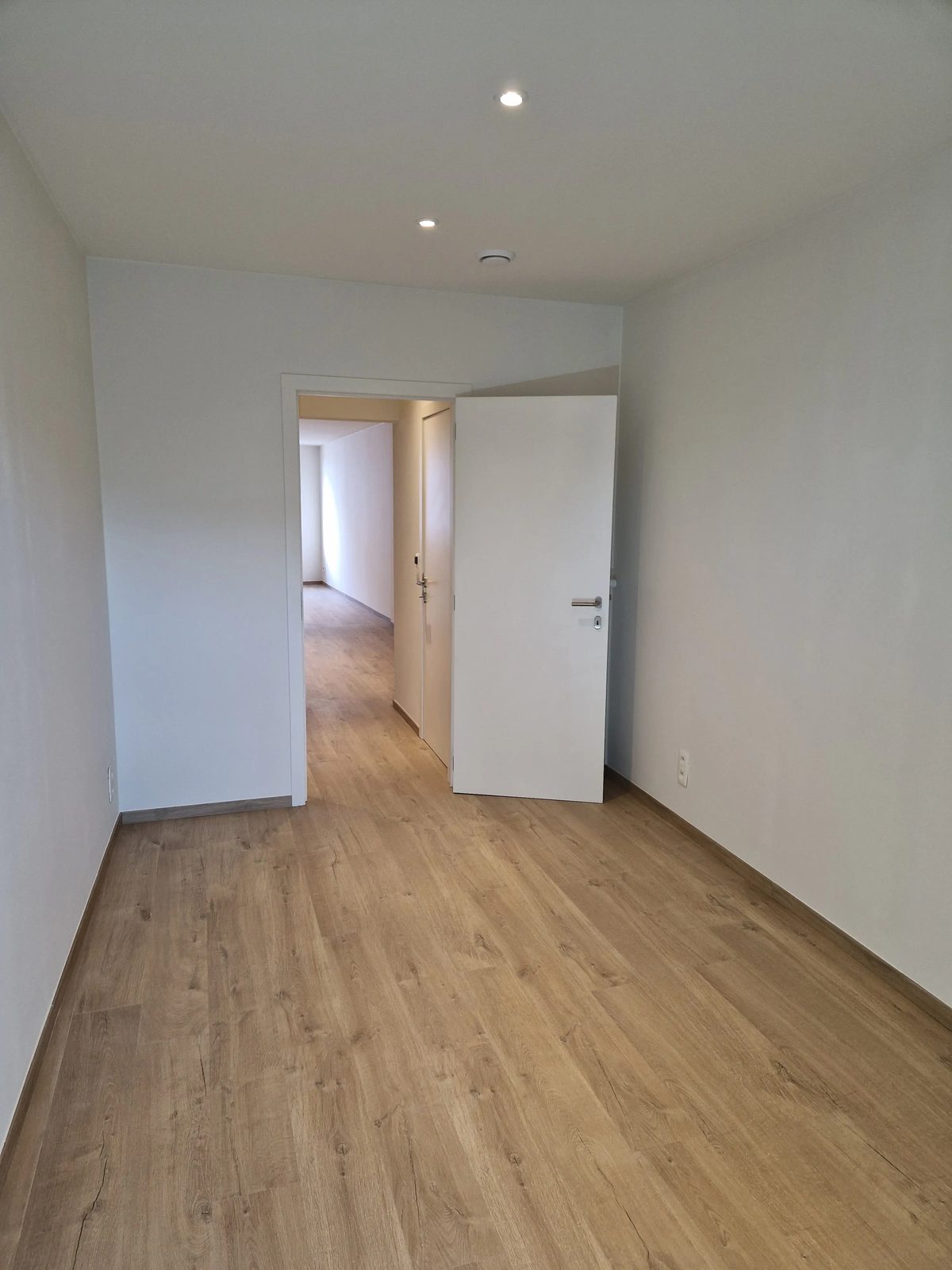 Slaapkamer met zicht naar de deur en de en-suite badkamer van het appartement aan de Kloosterstraat