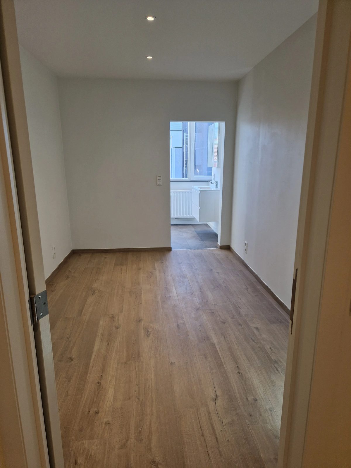 Slaapkamer gezien vanaf de deur van het 1-slaapkamerappartement te huur op 't Zuid in Antwerpen