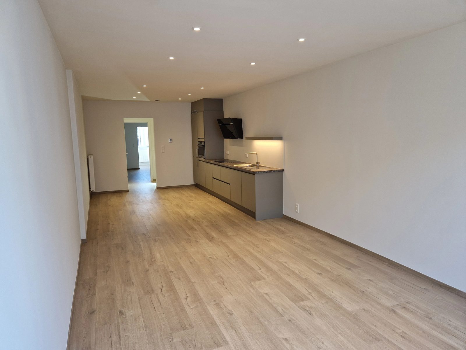Woonkamer met open keuken van het gerenoveerde appartement te huur aan de Kloosterstraat 183 in Antwerpen