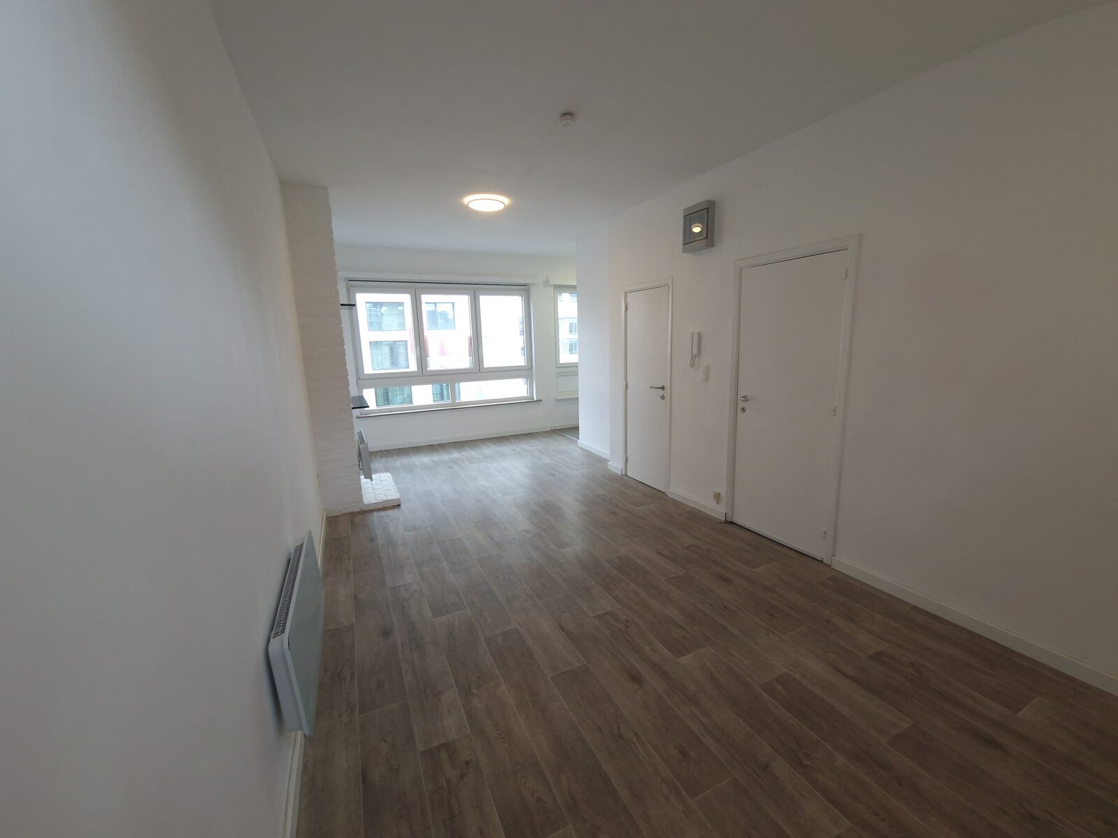 Leefruimte in de lengte gezien naar de raampartij, studio te huur in Antwerpen